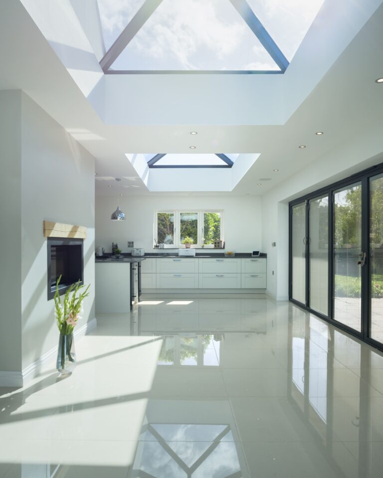 a photo of a large light kitchen with rooflights